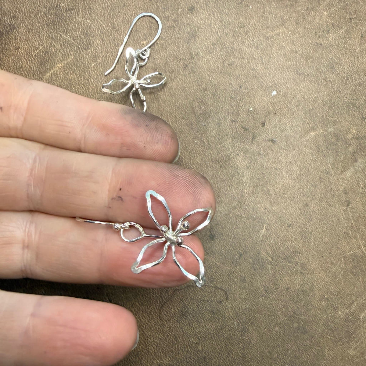 Detaljbild i hand av Juliblomman hängande örhängen i 925 silver