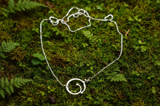 Nicalåset på tunn venetziakedja på mossa